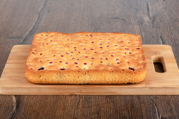 Closed berry pie on a wooden cutting board.
