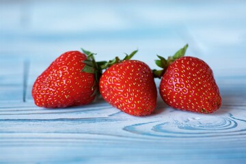 Fruit red ripe strawberries lies on a wooden surface. Ecological products grown in the garden