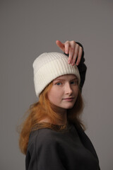 young girl model in white cap and gray coat isolated on grey background. Product photo mockup for fashion brands and marketplaces.