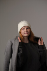 young girl model in white cap and gray coat isolated on grey background. Product photo mockup for fashion brands and marketplaces.