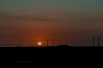 Por do sol e torres de energia