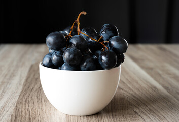 Bunch of blue grapes in a white bowl