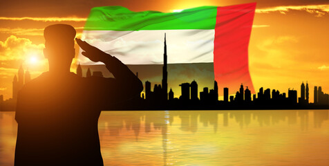 Silhouette Of A Solider Saluting Against the flag of UAE. Concept of national muslim holidays....