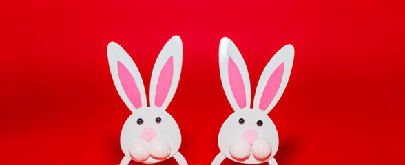 Banner,advertisement image.Two Toy Rabbit Bunny symbol of new year 2023 on red background.Christmas or New Year concept.Copy space.