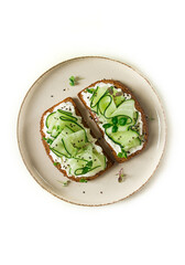 Breakfast, cereal bread sandwiches, cream cheese, sliced cucumber, with micro greenery on a light table, close-up, top view, selective focus, no people,