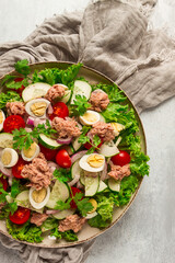 Tuna salad, vegetable salad with quail eggs, lettuce, red onion and cucumbers, on a light gray table, keto food, lifestyle, healthy eating, selective focus, top view, no people,
