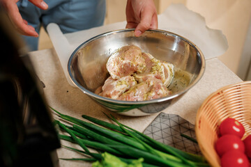 The man's hands prepares delicious juicy meat steak on an electric grill on wooden table. Smoke in the home kitchen