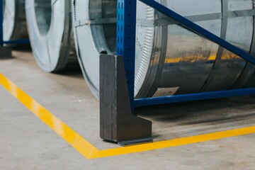 Yellow markings on the floor and a metallic round detail at the factory, close-up