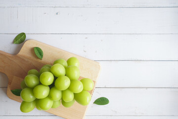 bunch of green grapes on a white wooden table - 539198505