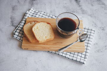 Hot coffee in a cup and bread for a delicious breakfast.