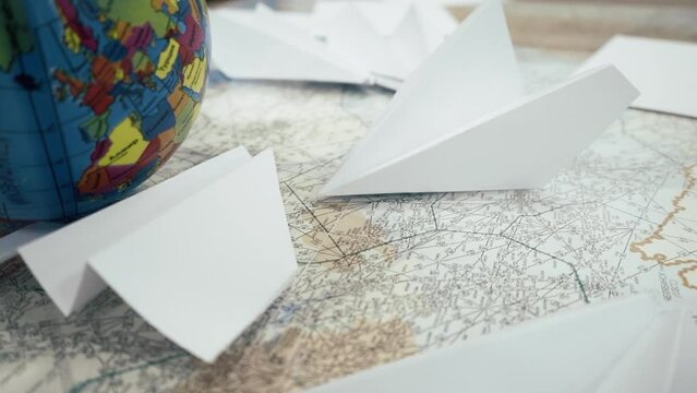 Travelling concept. Top view paper plane toy airplane above the world map. High quality FullHD footage