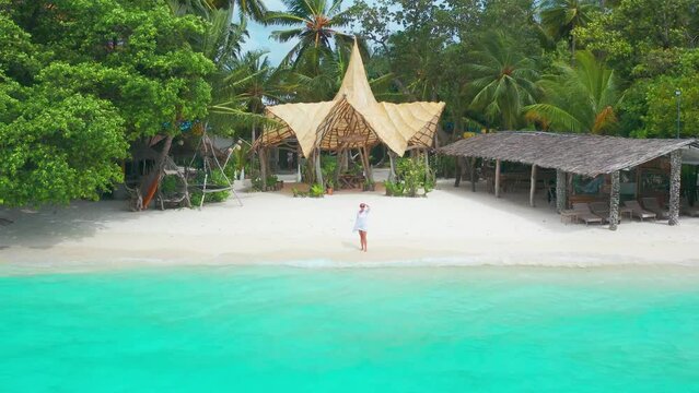Aerial view of alone young beautiful beach woman in Thinadhoo island, Maldives.