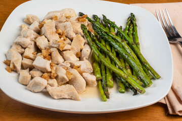 chicken bites top with sautyeed onions and asparagus