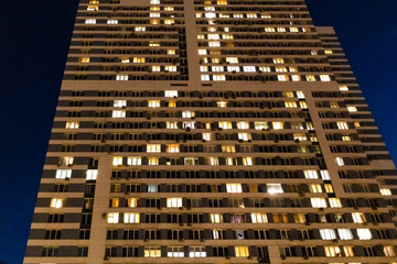 facade of high-rise apartment house in city in night