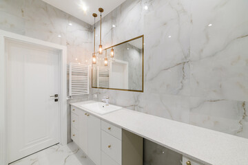 bathroom interior design with light tiles and a mirror