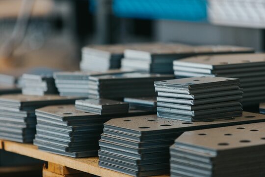 Bunch Of Different Kinds Of Connecting Plates Stacked In Neat Piles