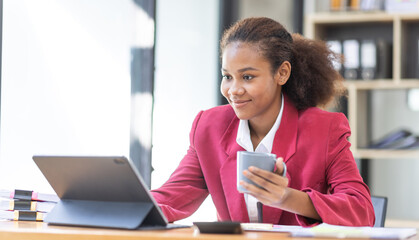 Smiling young African american female Finance Entrepreneur sitting in workplace office hoding...