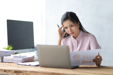 Serious business woman working on laptop in office.