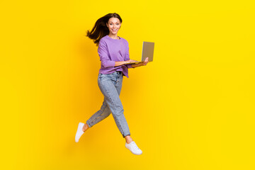 Full length photo of adorable positive girl hold device gadget netbook hurry move go empty space work isolated on yellow color background