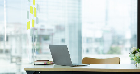 Laptop on a desk in an open financial office.