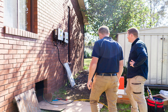 sunlit electricians installing solar power to house