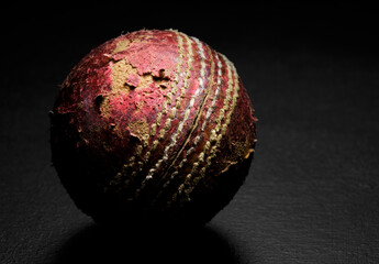 Close-up of a leather cricket ball on a black background fine art