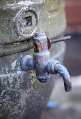 An einem alten Bierfass ist ein Ablasshan angebracht.
