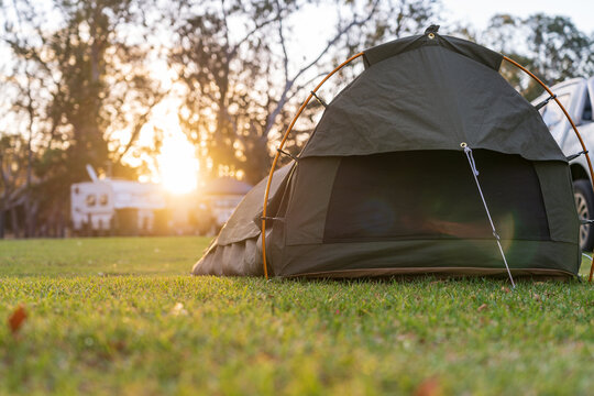 Low angle view on a sleeping swag set up on a grassy area of a campground at sunset