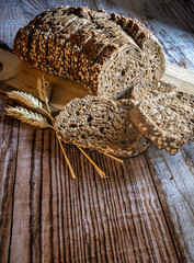 Slices of fresh bread and ears of corn on a rustic table