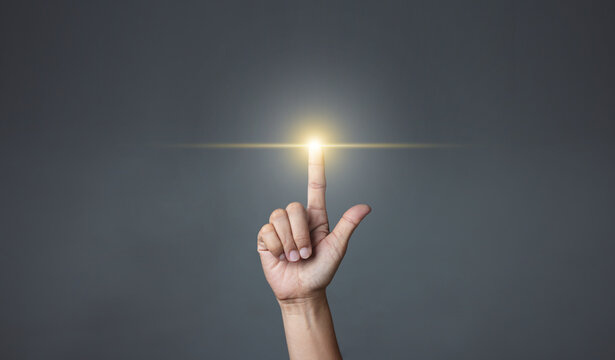 Hand pointing to an empty area on a dark background.