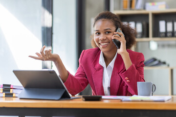 Young businesswoman cheerful african american lady working at workplace office, workdesk with laptop financial documents having phone conversation, copy space
