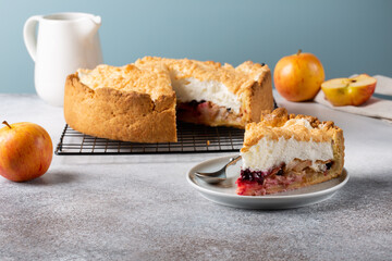 Apple pie with berries and meringue on top. Homemade apple tart on concrete background.