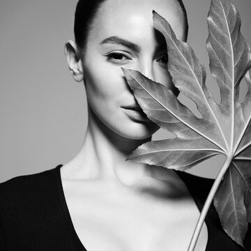 Portrait of a beautiful woman with grass leaves in her hands