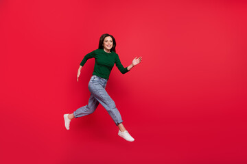 Full length photo of active excited lady run fast rush shopping wear trendy green long sleeve shirt isolated on bright red color background