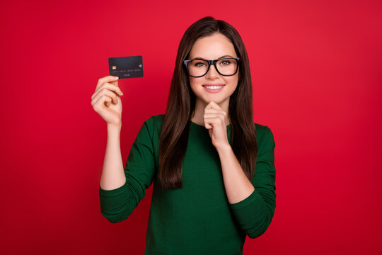 Photo of attractive woman bank client card user hand touch chin dressed stylish green outfit specs isolated on shine red color background