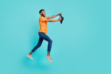 Fototapeta na wymiar Full size profile photo of crazy cheerful person arms hold wheel jump hurry rush isolated on teal color background