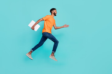 Fototapeta na wymiar Full length profile photo of crazy guy jump hurry rush empty space hold laptop isolated on teal color background