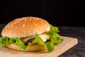 Burger with beef patty on a wooden plate