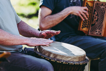 Mains d'un homme en train de jouer du djembé, instrument à percussion