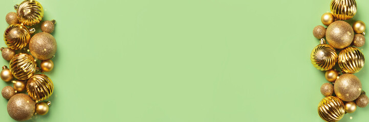 Christmas banner with golden glitter balls and decorations on green background with copy space. Wide panoramic header