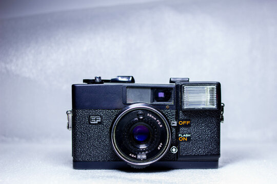 Close up photo of retro old analog camera with lens 38mm illuminated with light painting. Vintage style horizontal film.