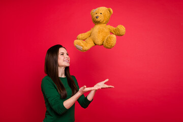 Photo of cute brunette lady catch toy wear green shirt isolated on red color background
