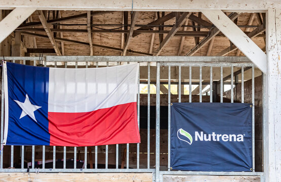 A Horse Stall At A Show With A Texas Flag And Nutrena Banner.