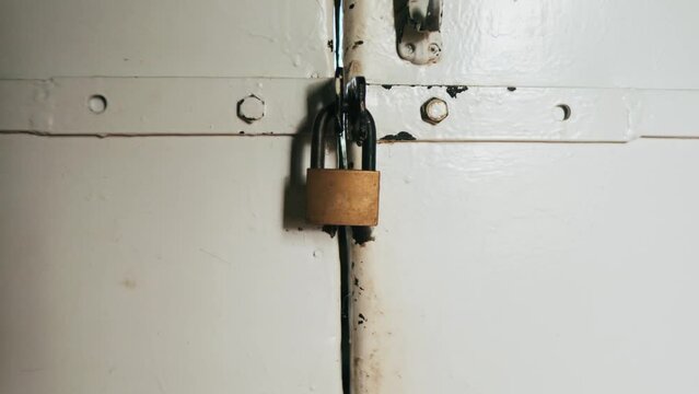 Camera Zoom Out. the lock on the white door. white iron door with an old lock.  