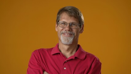 Smiling bearded mature man 50s 60s years old wearing red shirt isolated on solid yellow background studio. People sincere emotions lifestyle concept. Looking camera.