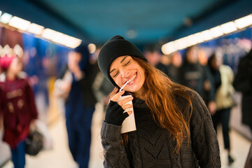 Shot of an adult woman drinking something from a to go cup.