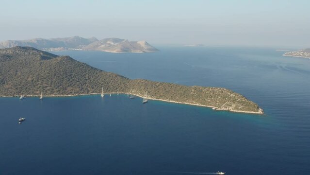 Aerial view of Mediterranean bay of Kas in Turkey. Panoramic view in showing bay, yachts, sailing boats, and surrounding mountains landscape including Greek island of Kastellorizo