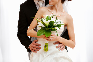 Wedding: Bride in Front of Groom with Bouquet
