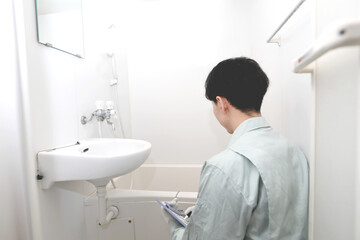 浴室を点検する作業員の男性