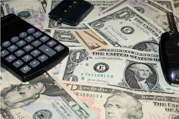 car keys and canculator on the photo of money. calculate the cost of a car trip